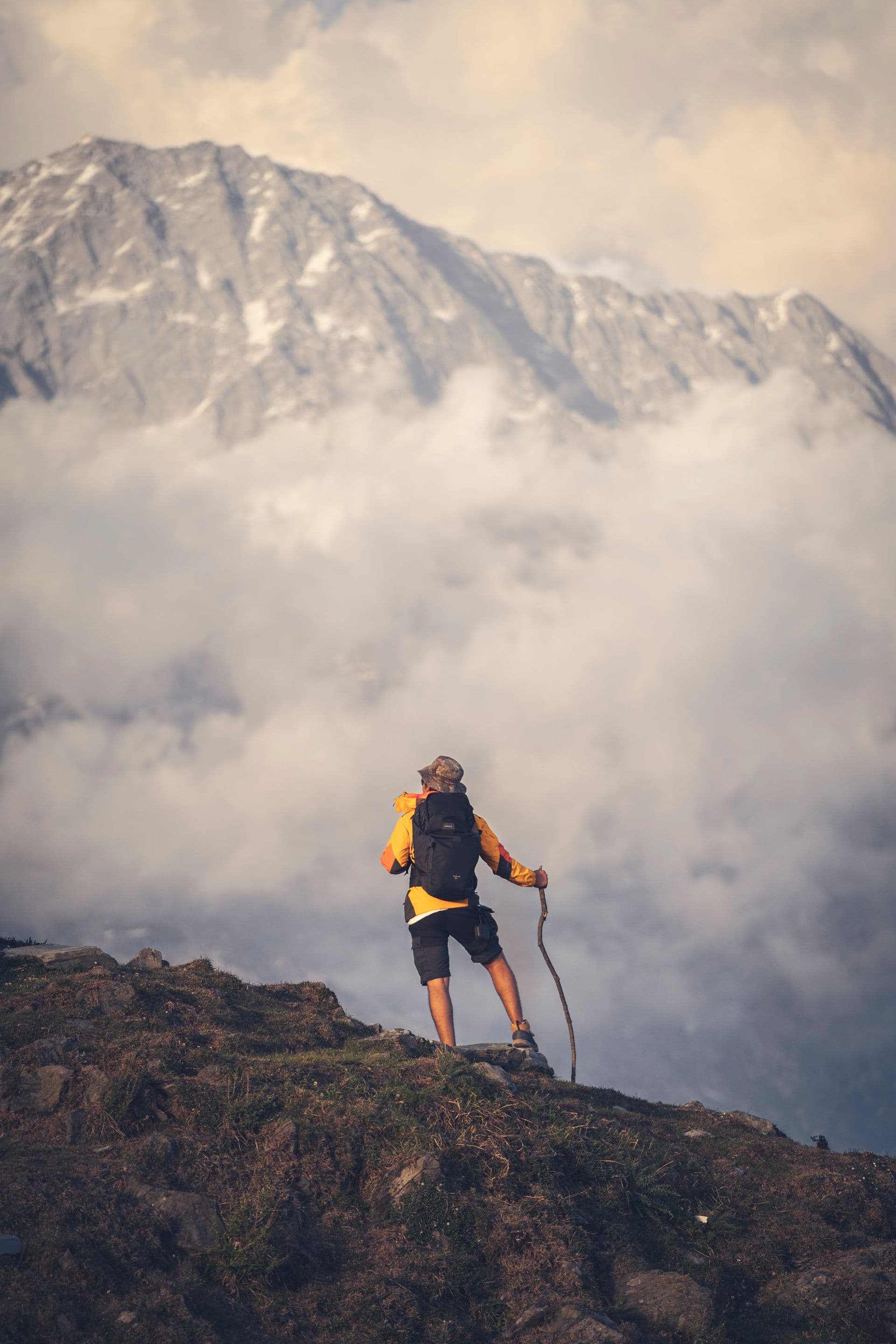 A trekker above the clouds facing the Dhauladhar